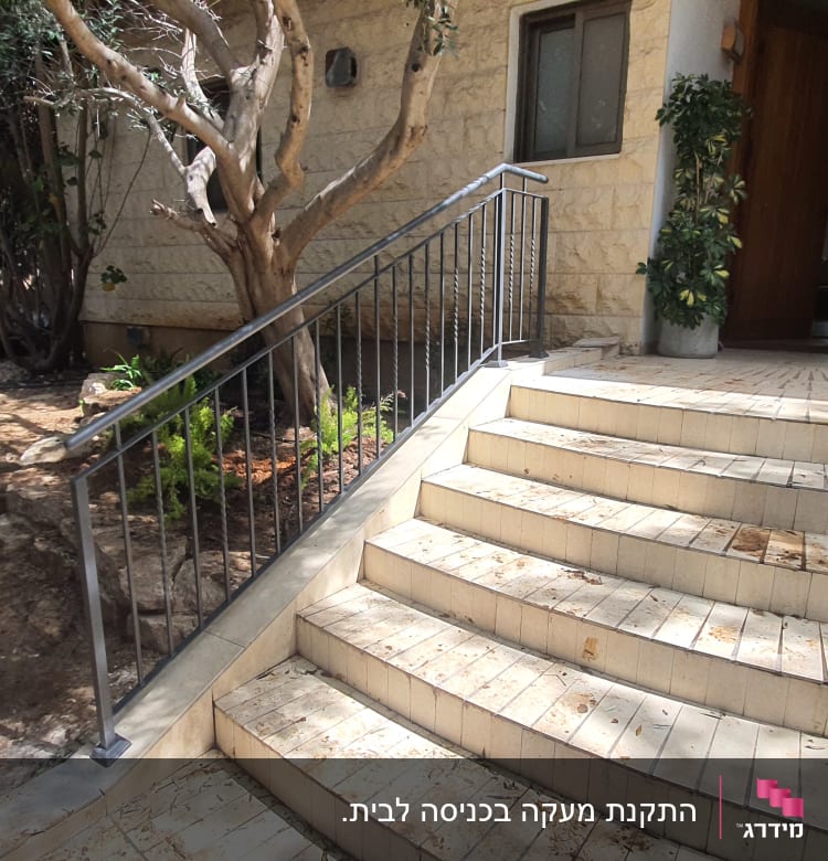 מעקה מתכת לאורך מדרגות חיצוניות לבית